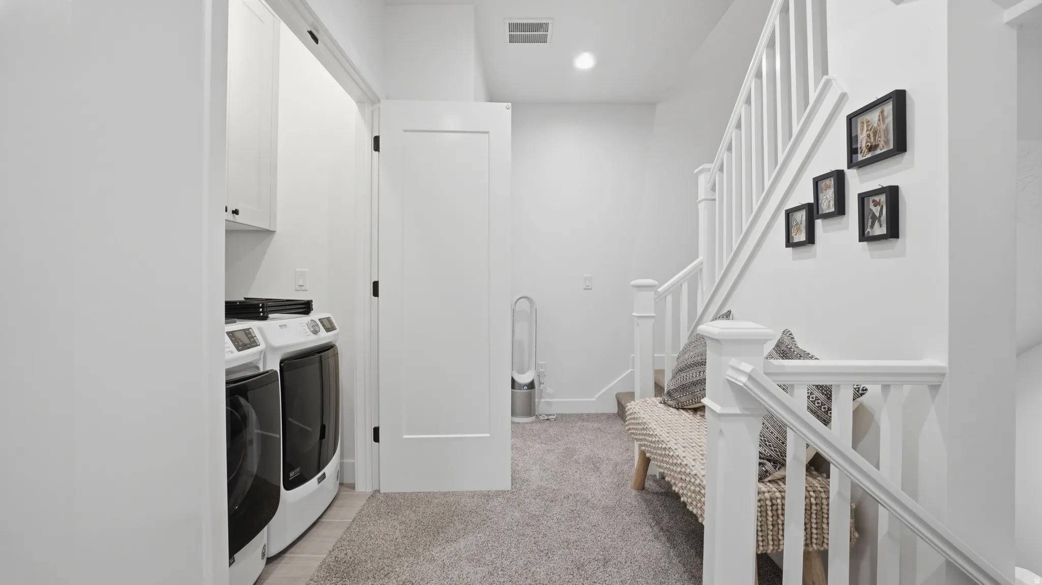 Dedicated laundry area featuring white cabinetry