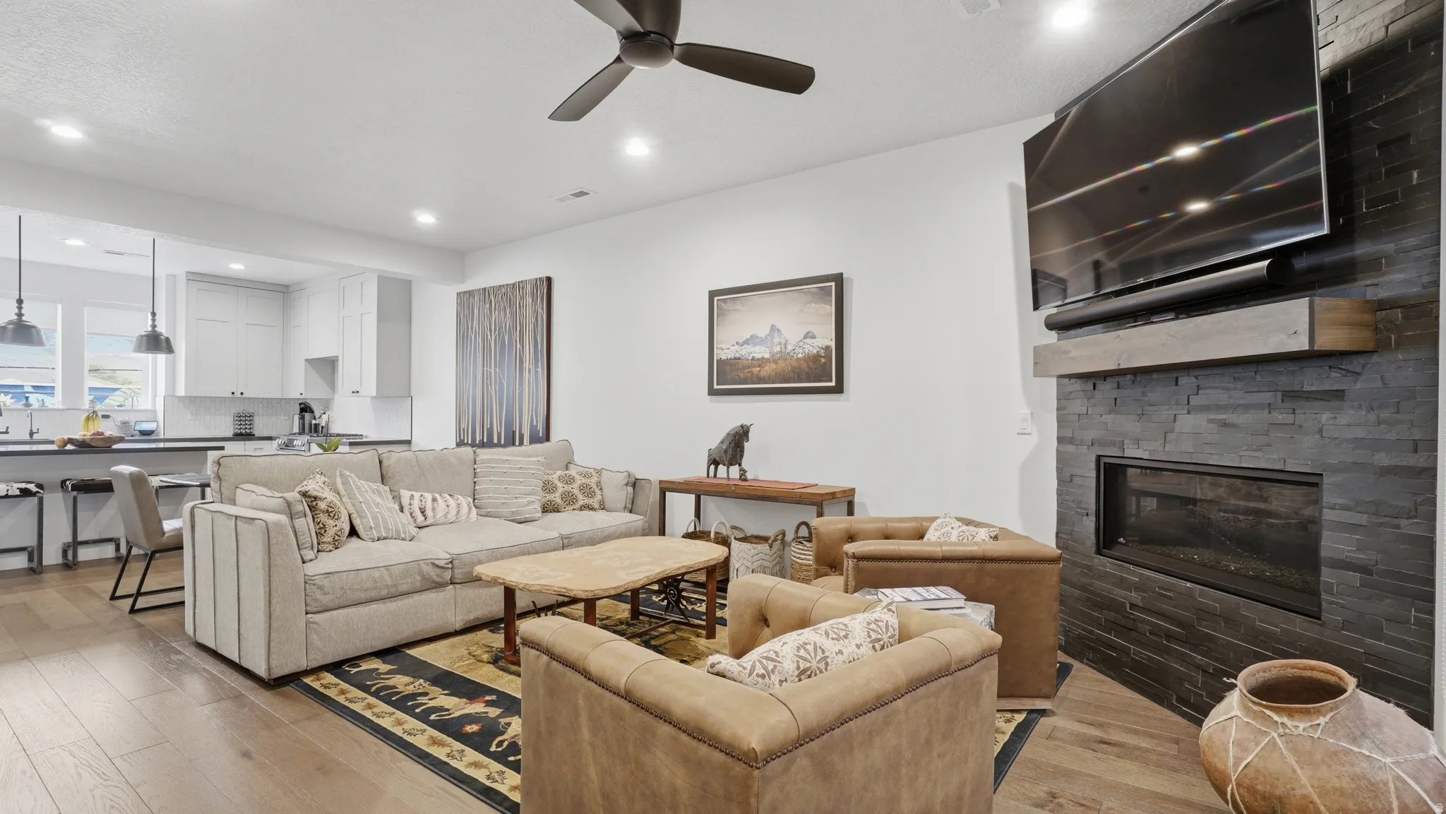 Open-concept living space featuring wood-finish flooring, a contemporary ceiling fan, and recessed lighting