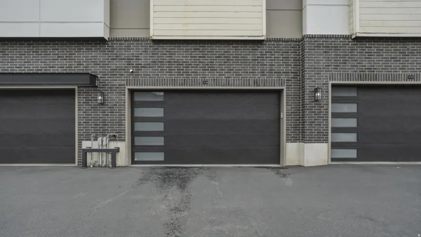 Modern garage doors set against a dark brick facade