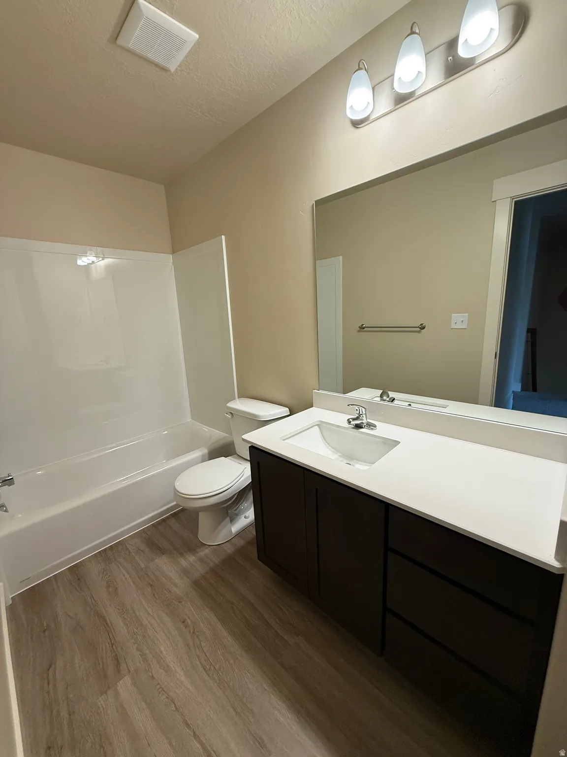 Contemporary bathroom featuring a dark wood-finish vanity with a white countertop, an undermount sink, and chrome fixtures