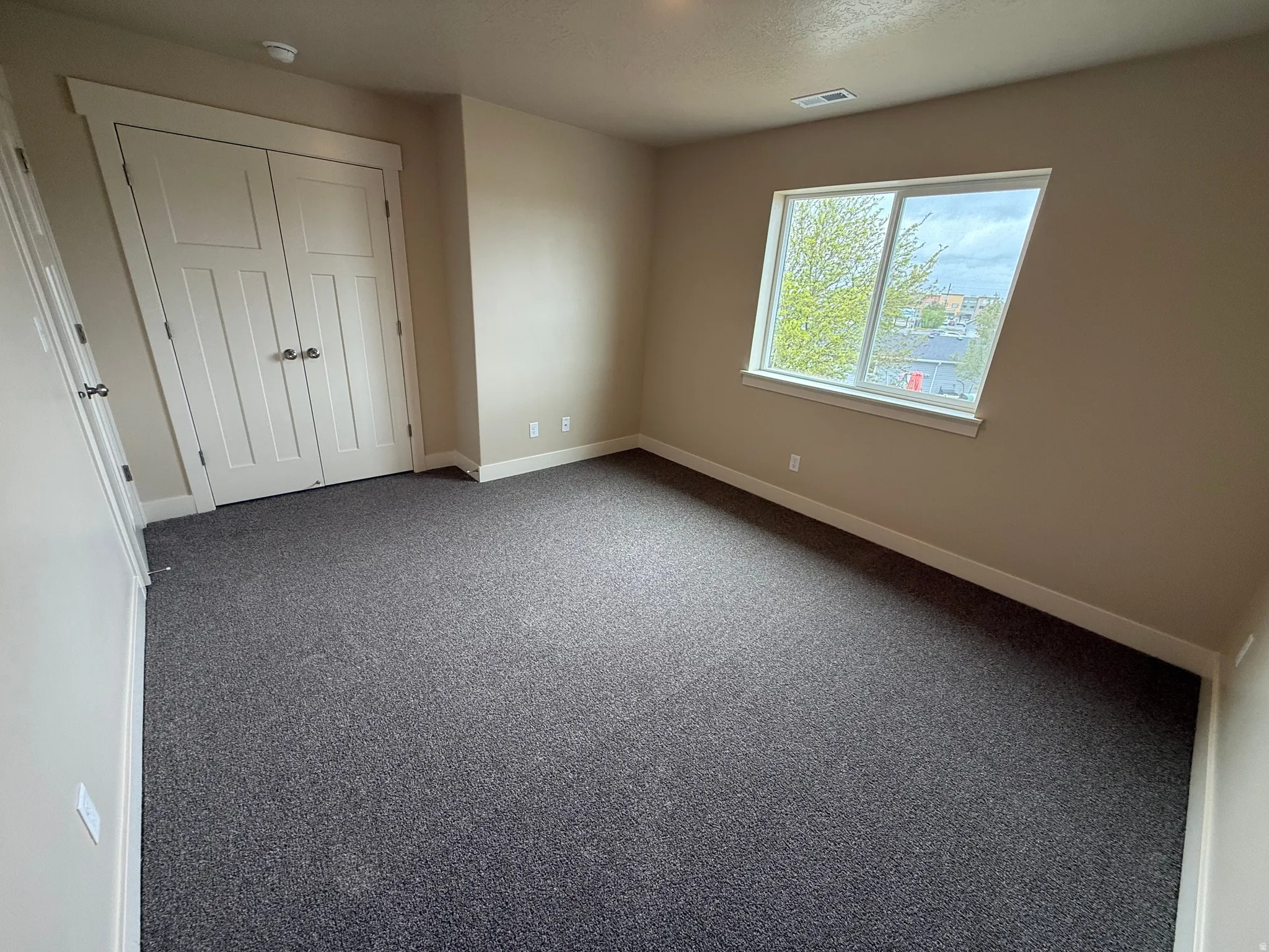Room featuring neutral wall tones, gray carpeting, and white baseboards