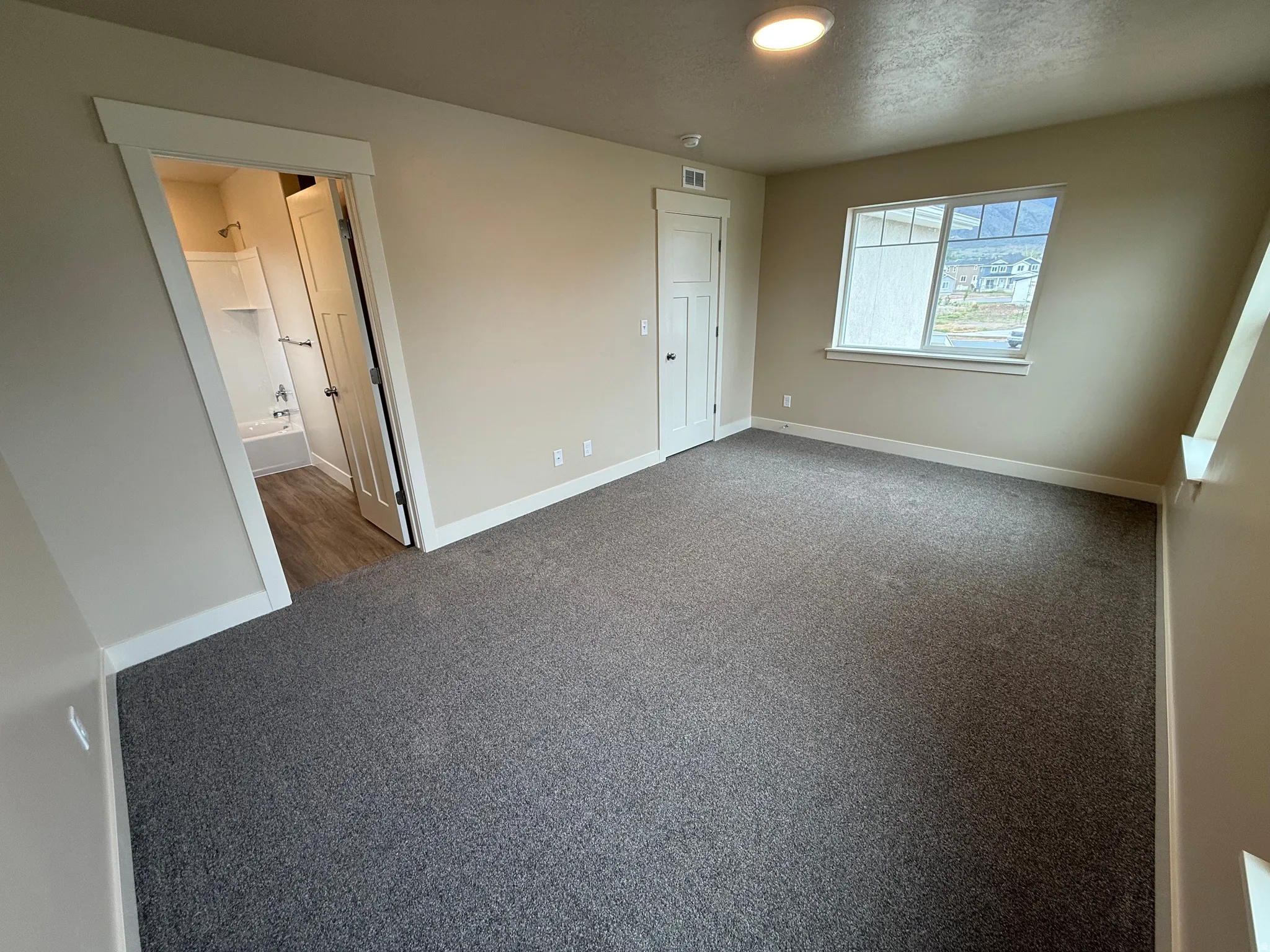 Spacious room featuring gray carpet flooring and neutral wall tones
