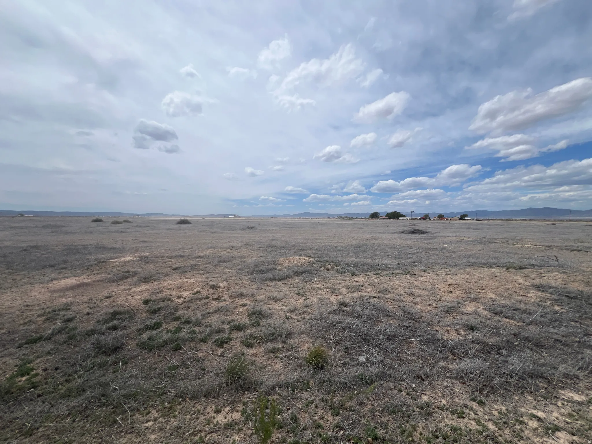 Expansive undeveloped land featuring natural terrain and distant mountainous horizons