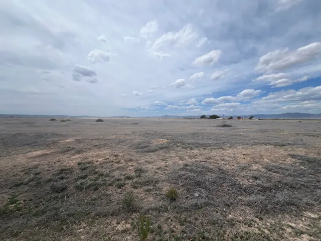 Expansive undeveloped land featuring natural terrain and distant mountainous horizons