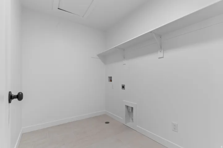 White interior walls with an overhead shelf and tile flooring