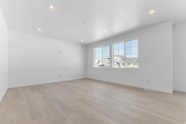 Recessed lighting with light wood-finish flooring