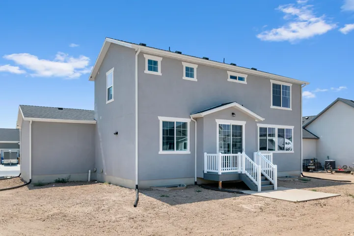 Two-story stucco exterior with white trim windows and a covered patio
