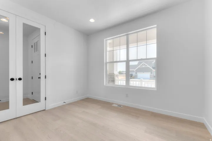 Light wood-finish flooring with white walls