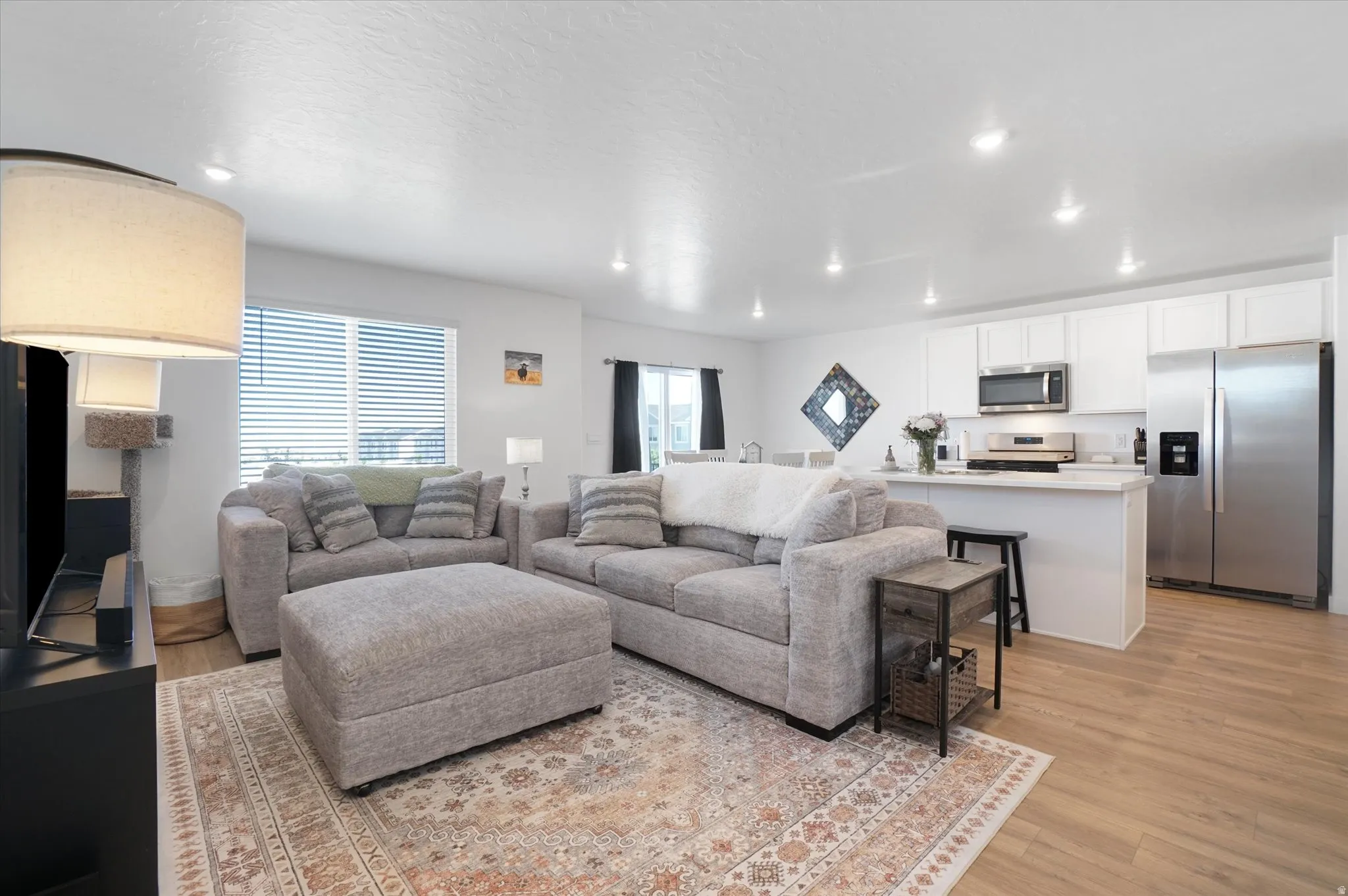 Open-concept living space featuring wood-finish flooring, recessed lighting,