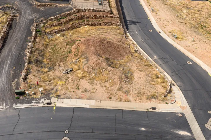 Graded building lot featuring established road frontage, sidewalk infrastructure, and streetlights