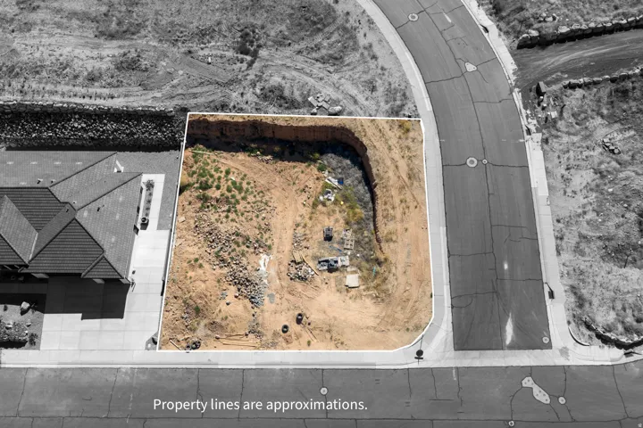 Cleared lot with visible property lines, bordering a paved street
