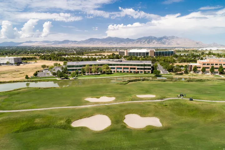 Expansive green golf course featuring sand traps and a golf cart path