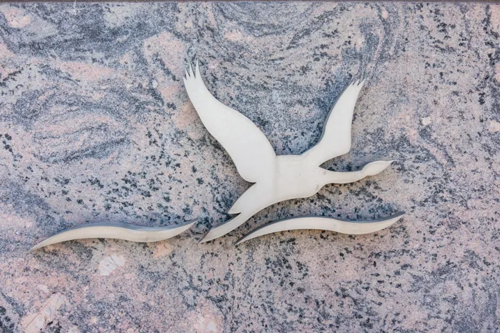 Decorative wall inlay featuring a bird silhouette and wave forms