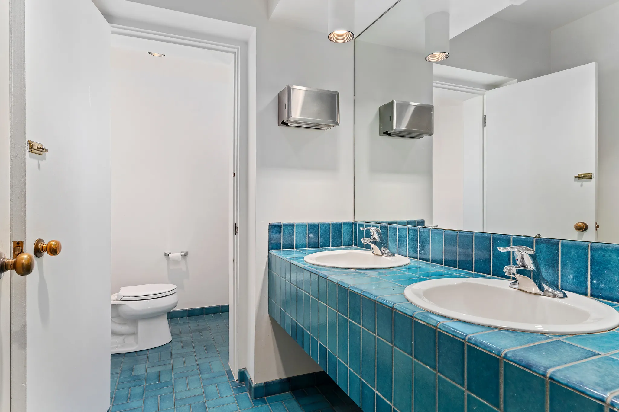 Dual vanity featuring blue tiled countertop and backsplash