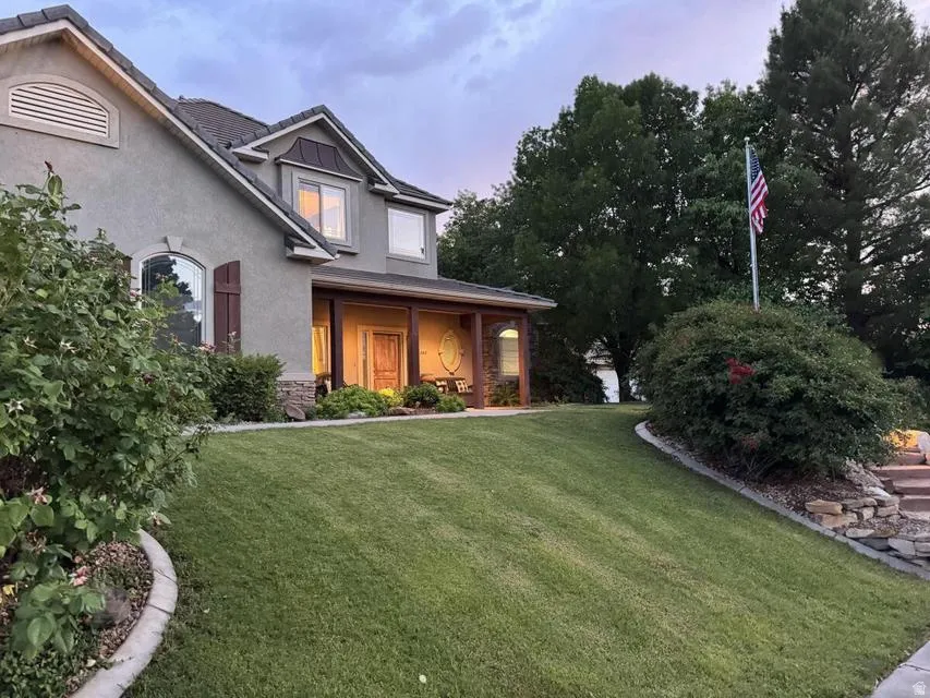 Stucco exterior with stone accents and a covered front porch featuring wood columns