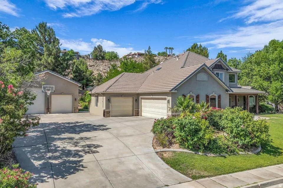 Stucco-finished residence featuring a tiled roof and an attached multi-car garage