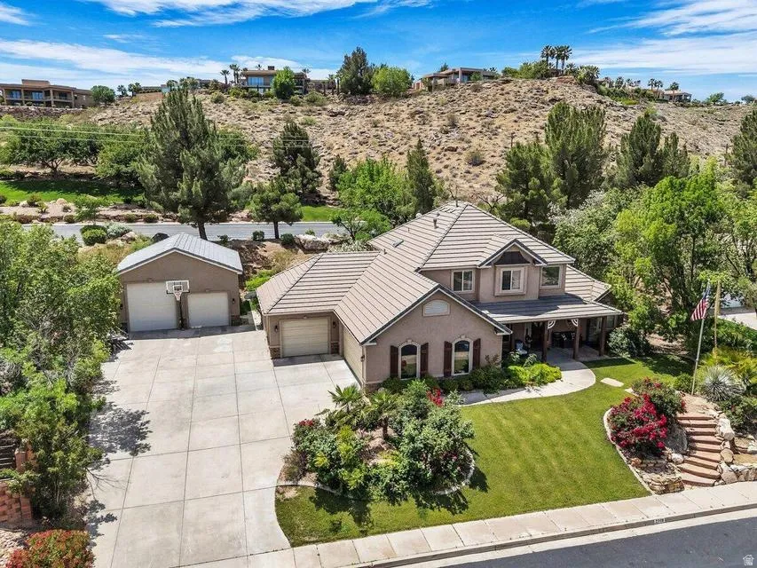 Spacious property featuring a two-story residence with a covered front porch, a detached two-car garage, and an attached single-car garage