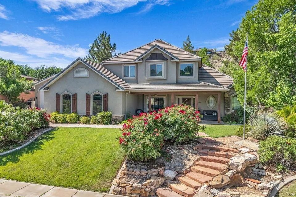 Stucco exterior residence with a covered porch, multi-pane windows, and a tile roof