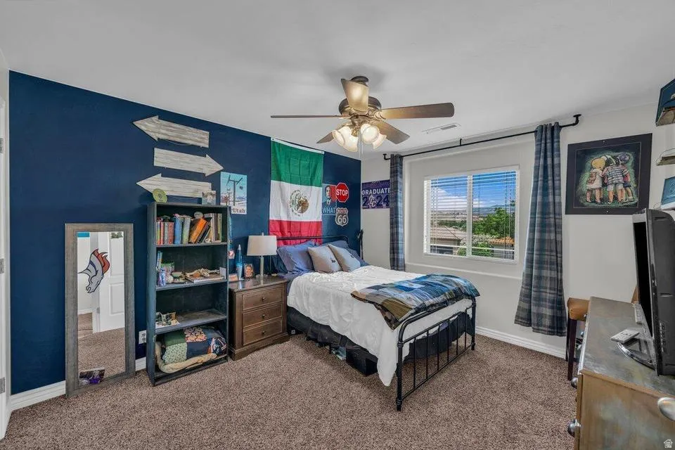 Carpeted bedroom with a window featuring horizontal blinds and plaid curtains