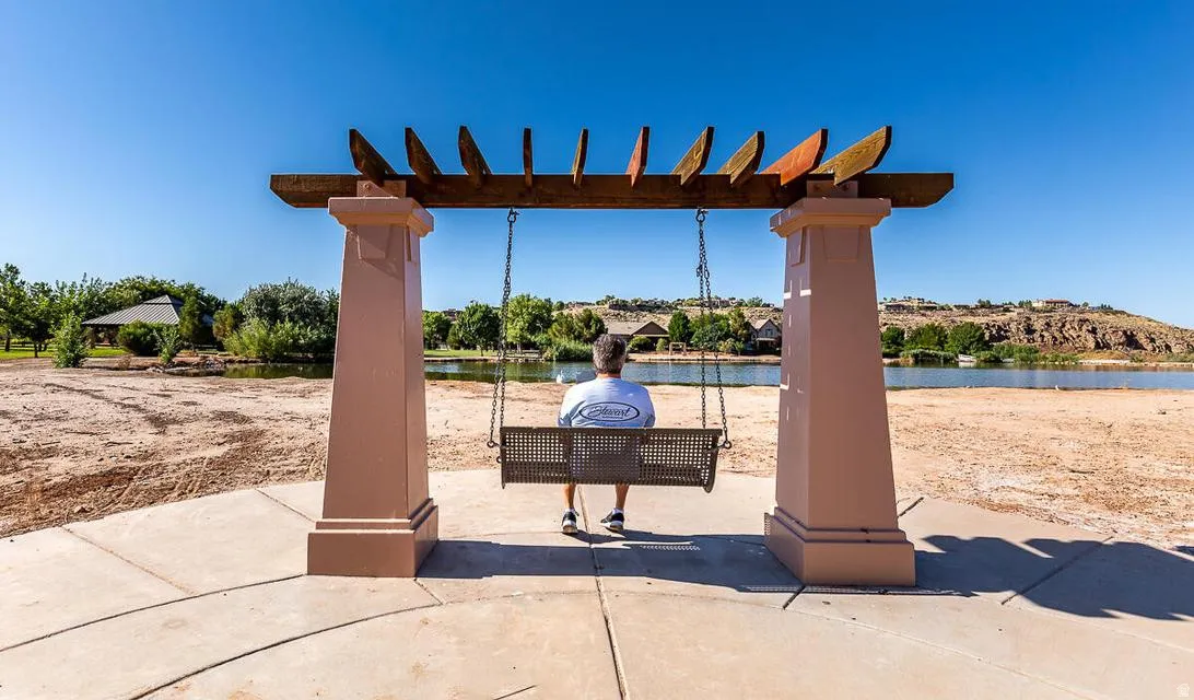 Outdoor swing feature with a wood pergola and two structural columns