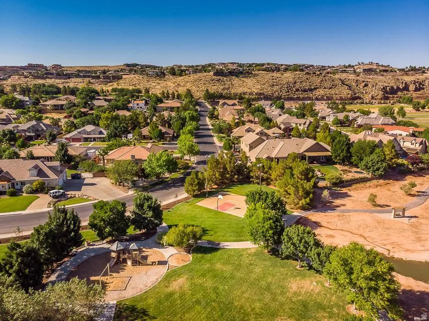 Aerial overview of a residential neighborhood with mature trees and paved streets