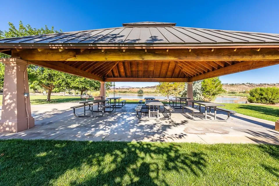 Covered outdoor pavilion featuring a metal roof, exposed wood beam ceiling, and concrete pillars