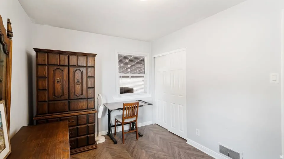 Room featuring light grey walls and wood-finish herringbone flooring