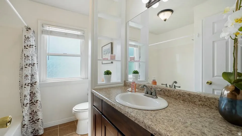 Bathroom vanity with an integrated sink, speckled countertop, and dark wood-finish cabinetry