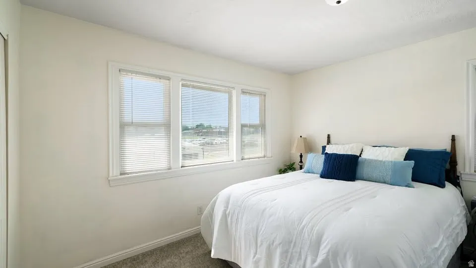 Bedroom featuring neutral wall tones, white trim, and light grey carpet