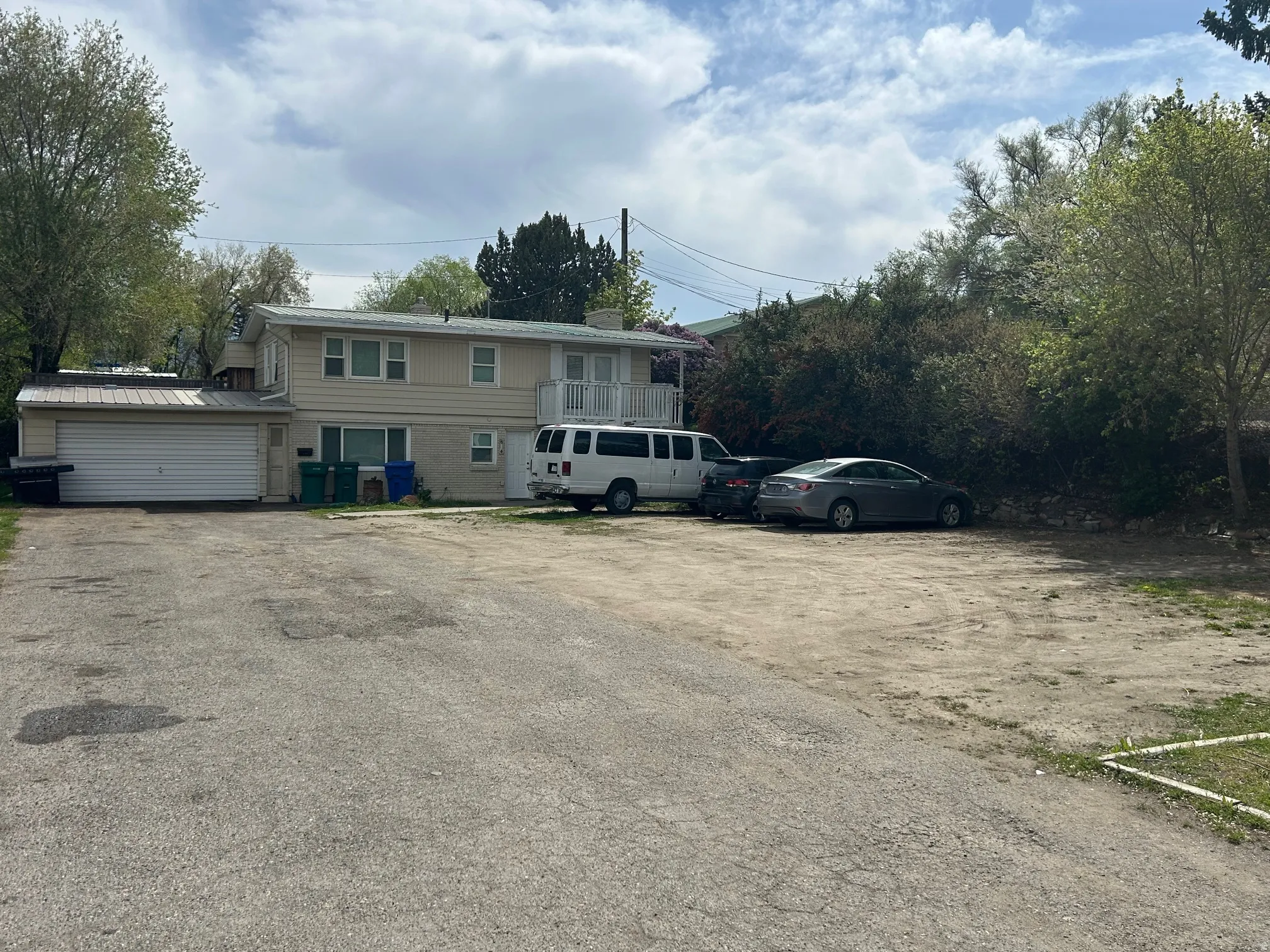 Two-story exterior with a ground-level garage and upper-level balcony and ample RV g or multiple car parking.