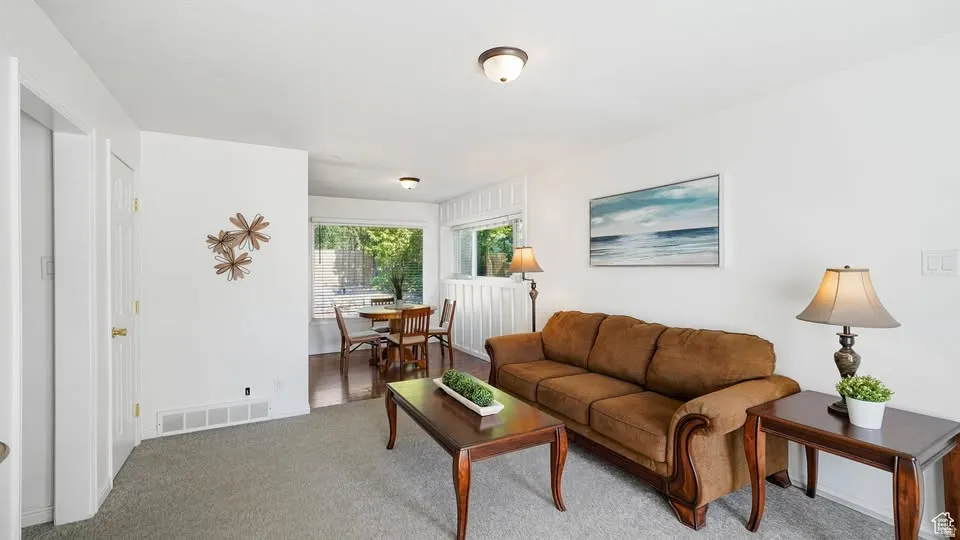 Carpeted living area with white painted walls.