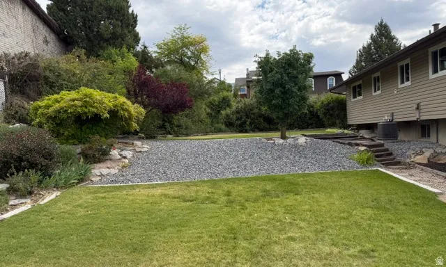 Expansive lawn area with a gravel landscape feature and mature trees