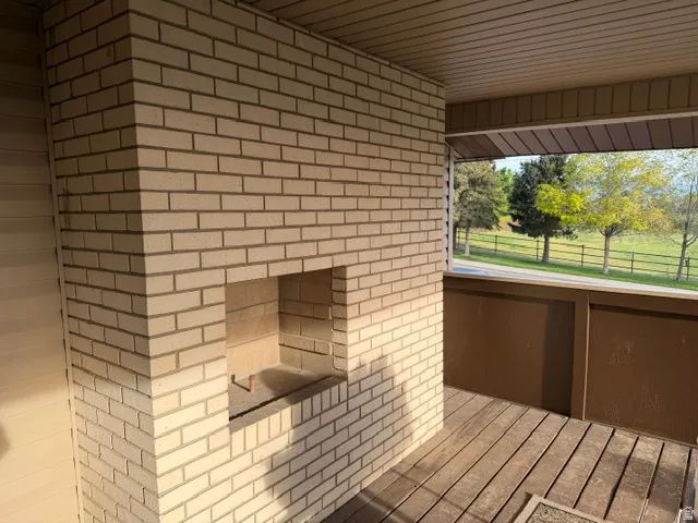 Outdoor living space featuring a light-colored brick fireplace with an integrated firebox