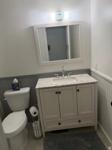 Light-toned bathroom featuring a white vanity with an integrated sink, a light-toned countertop, and a framed wall mirror
