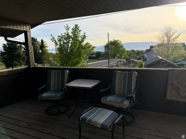 Elevated wood-finish deck with dark railing and overhead soffit