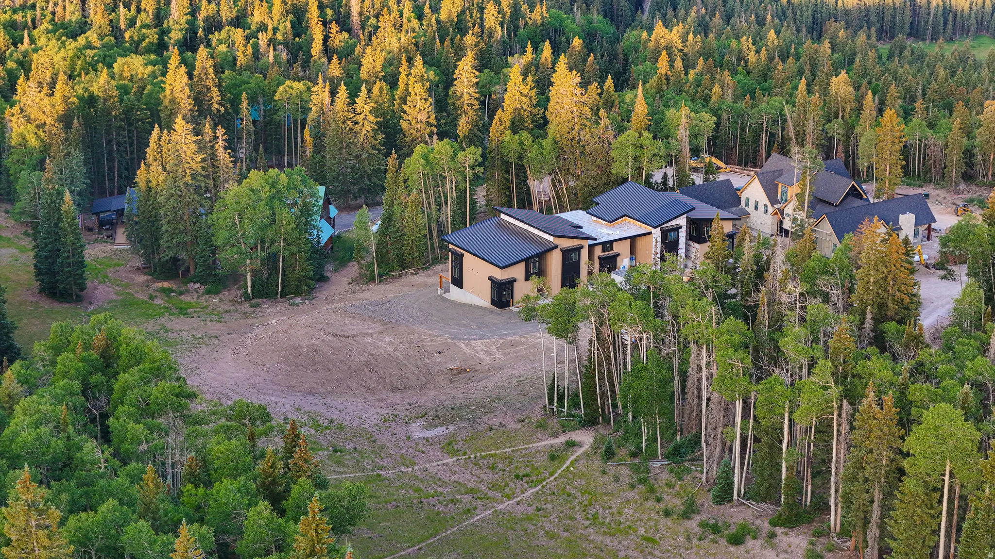 Contemporary multi-structure property featuring dark roofs and light-toned siding