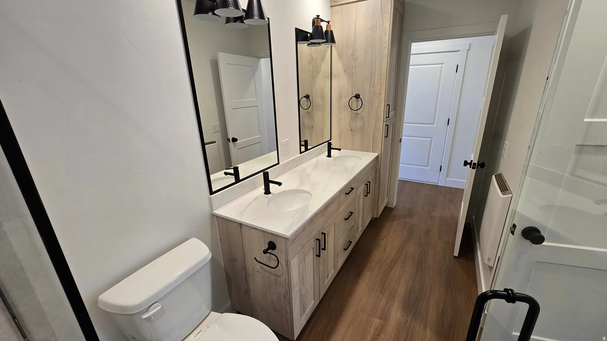 Dual vanity with undermount sinks, stone-finish countertop, and matte black fixtures
