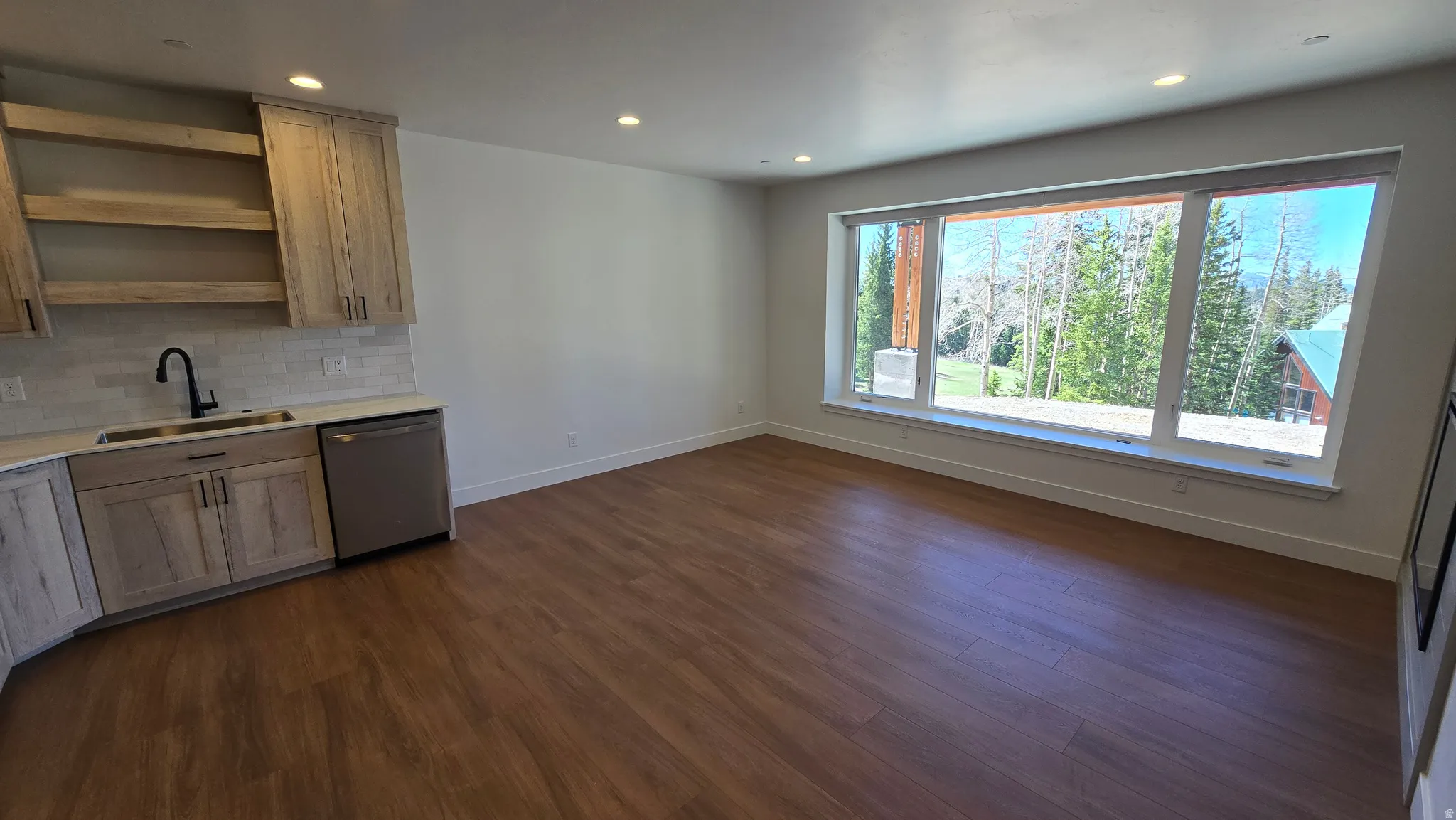 Expansive window offering a mountain and tree-lined backdrop
