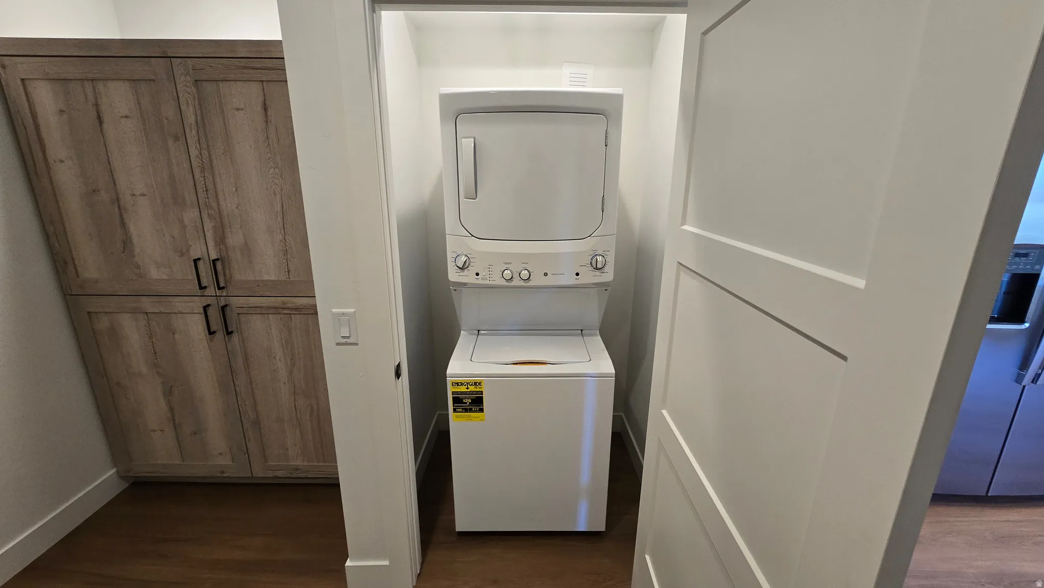 Compact laundry closet featuring a stacked washer and dryer