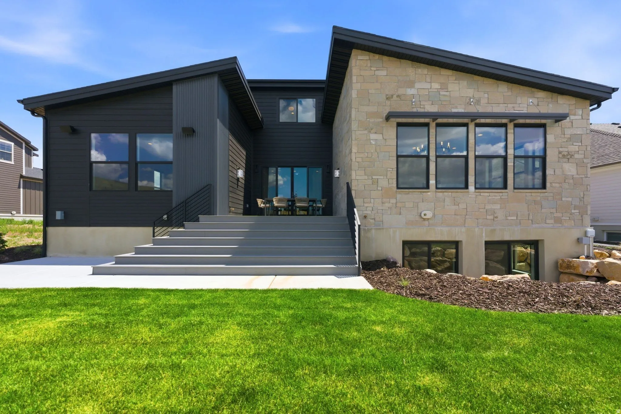 Modern exterior featuring dark siding and stone cladding
