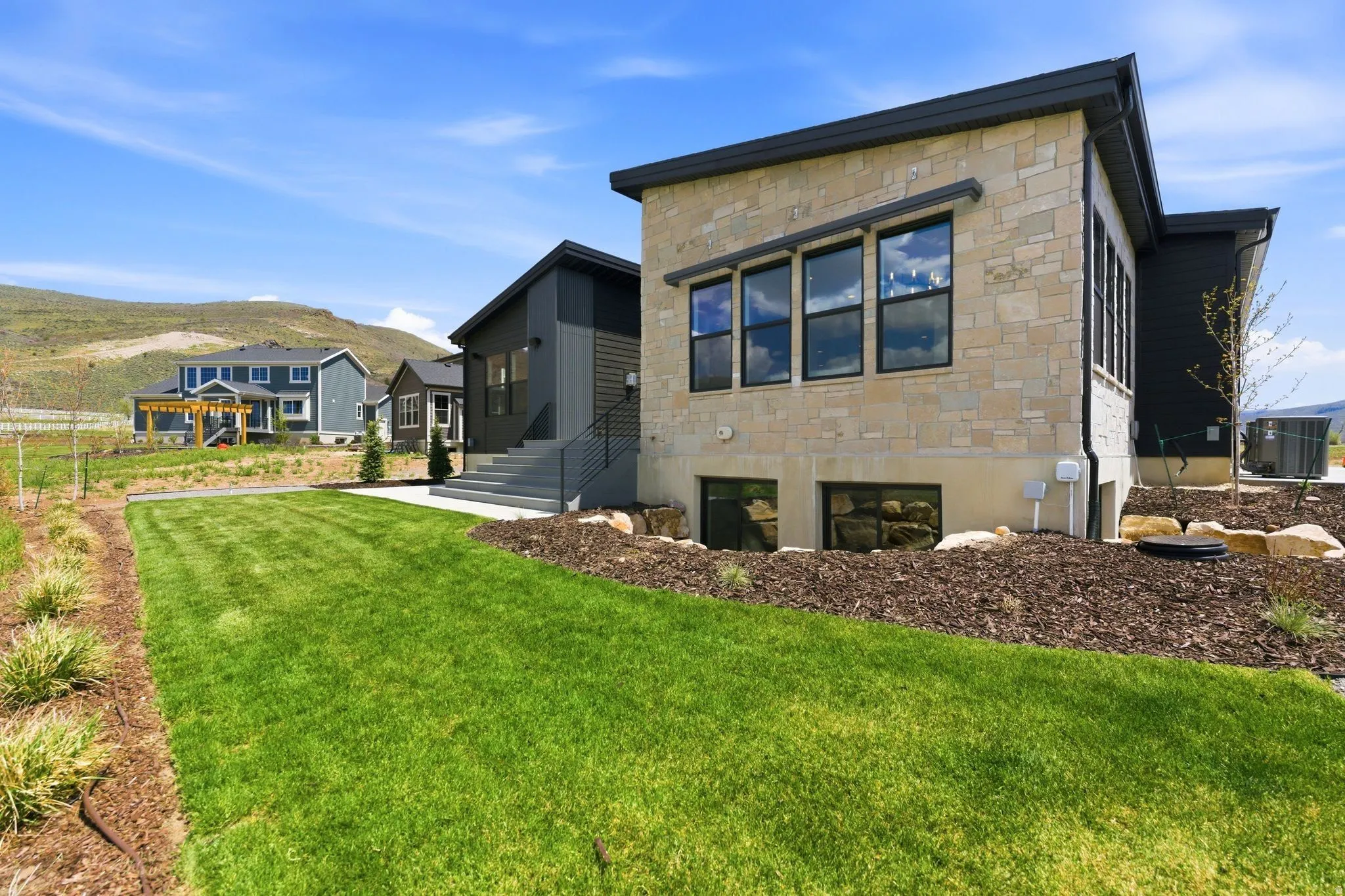 Modern exterior featuring stone veneer and dark siding