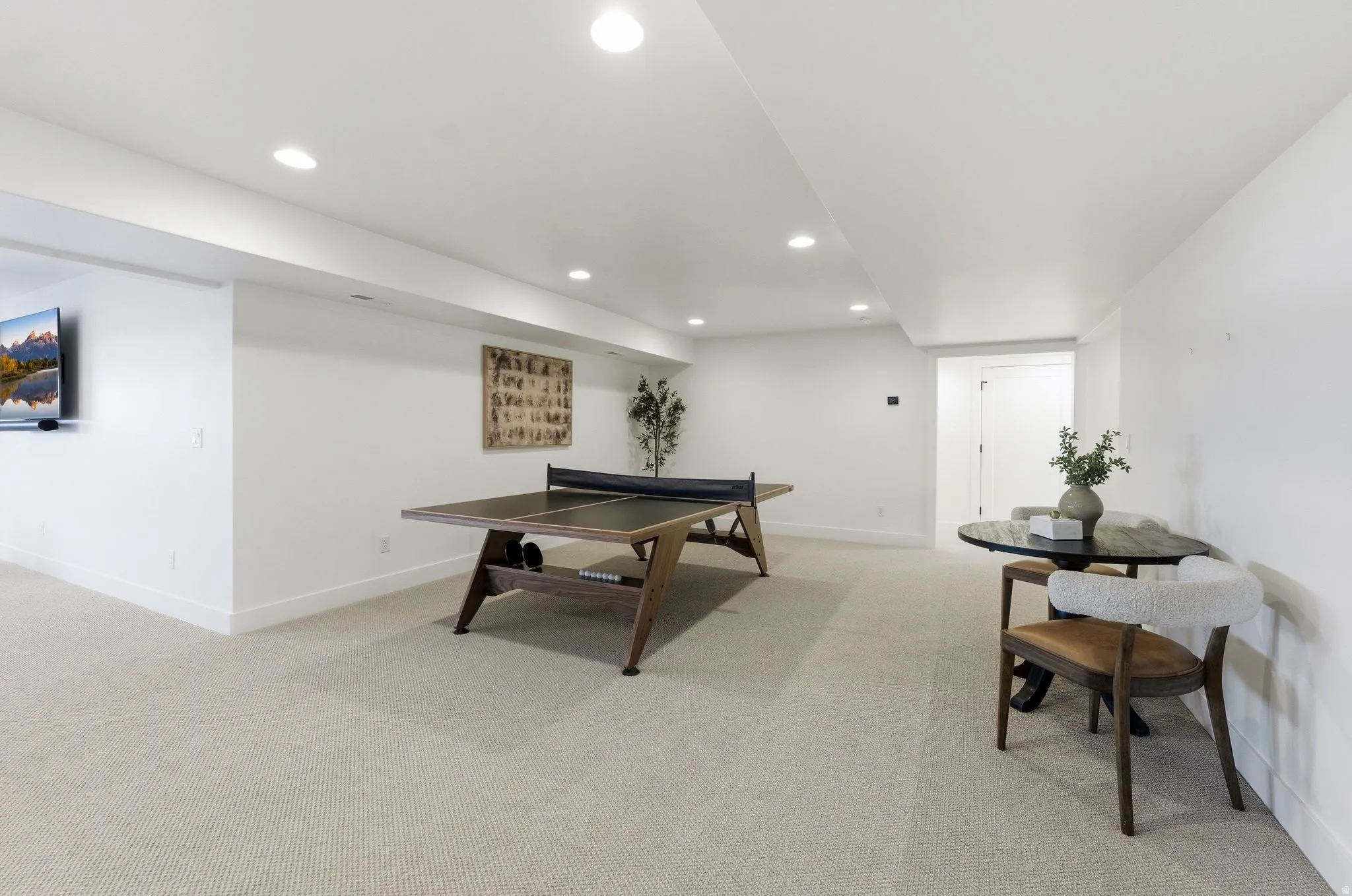 Spacious lower level featuring recessed lighting, a neutral carpeted floor, white walls, and a built-in entertainment area