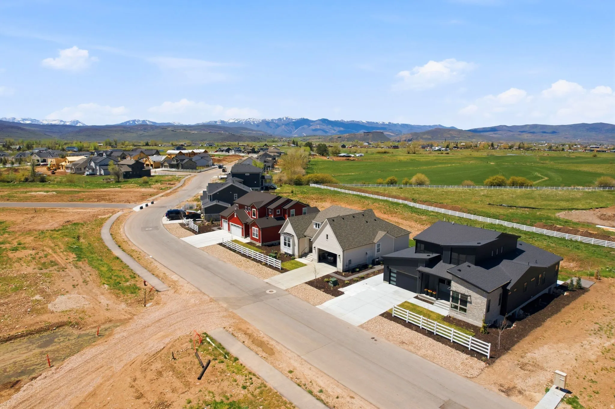 Modern architectural home with a dark-toned facade, light stone accents, and a multi-pitched roofline