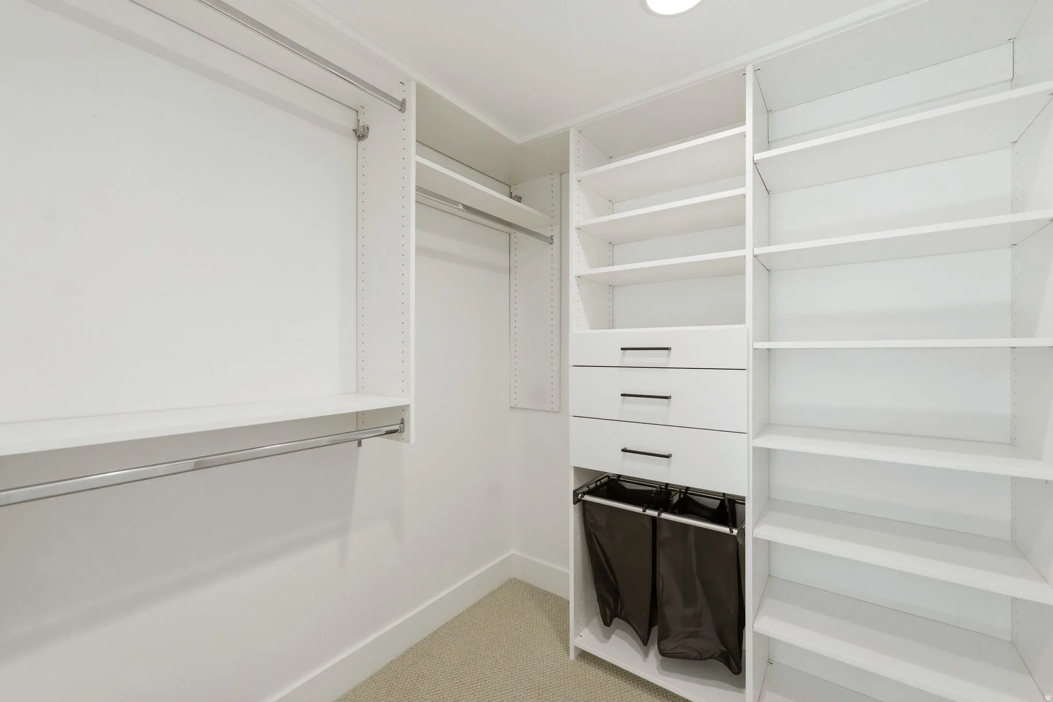 Custom closet system featuring multiple hanging rods, adjustable shelving, and integrated drawers with contemporary hardware