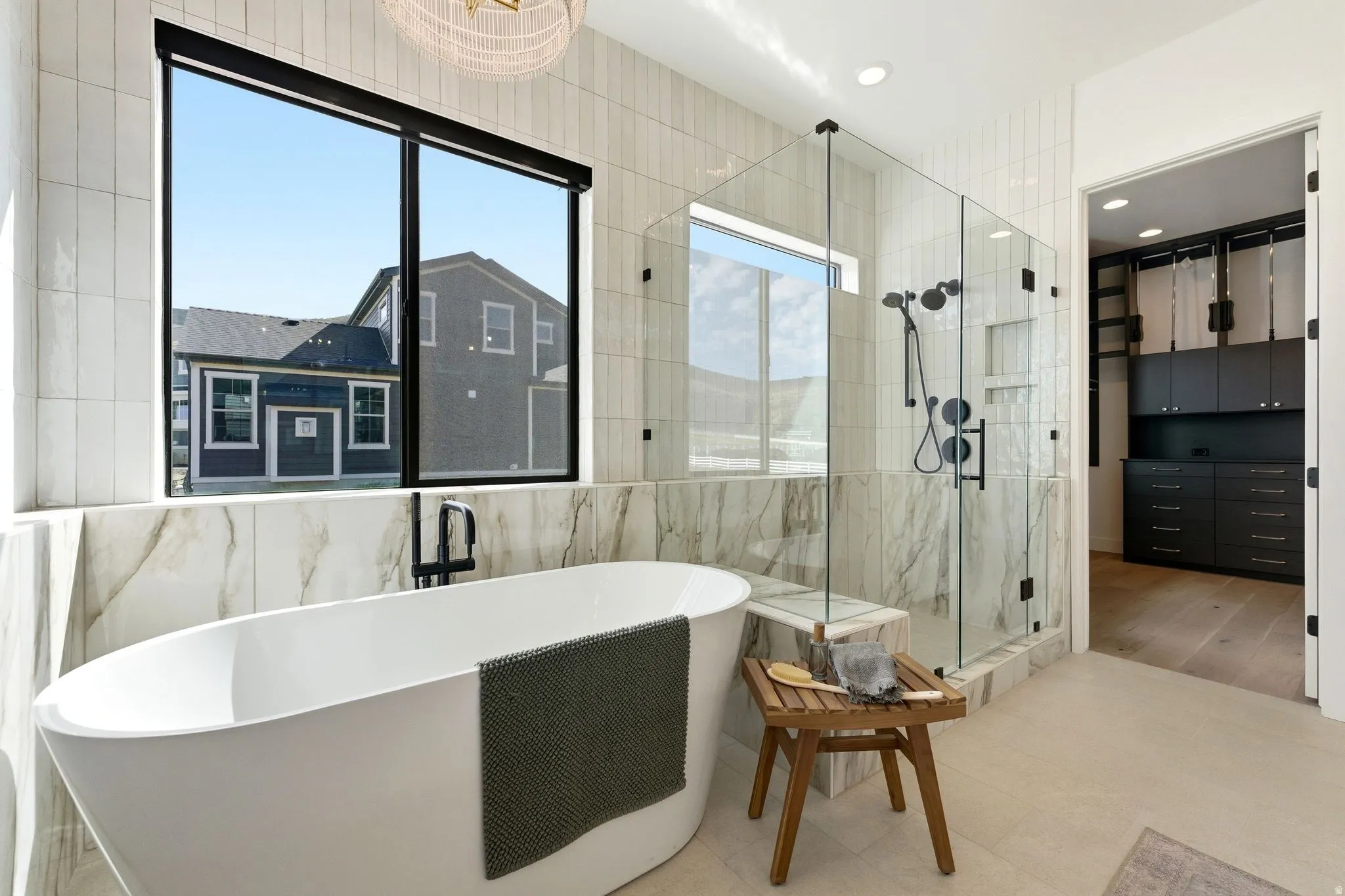 Freestanding soaking tub with a floor-mounted matte black faucet