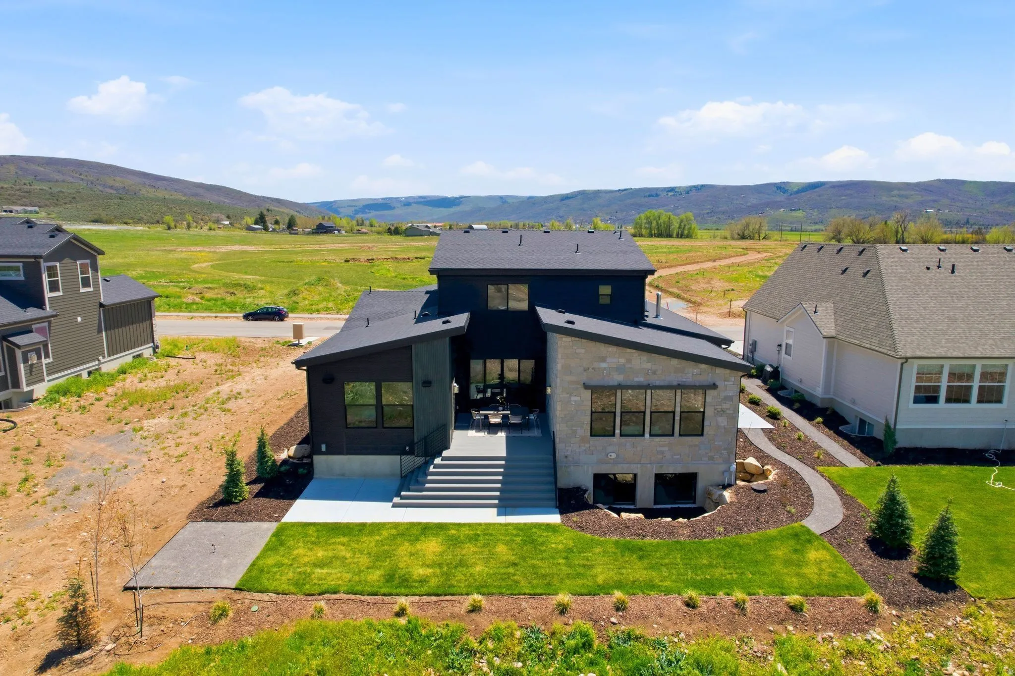 Contemporary residence featuring dark siding and light stone accents