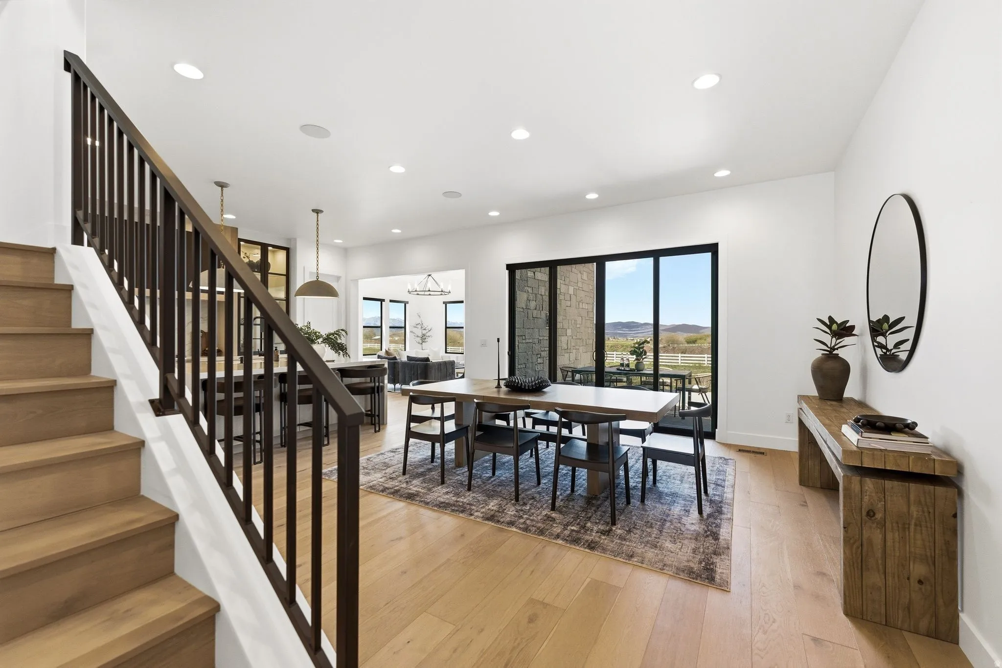 Wood-finish flooring throughout, featuring a staircase with dark wood balusters and handrail