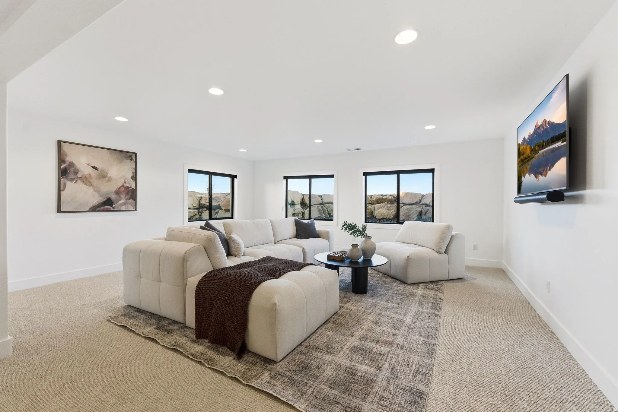 Spacious room featuring neutral carpet flooring, recessed lighting, and multiple windows with exterior rock formations