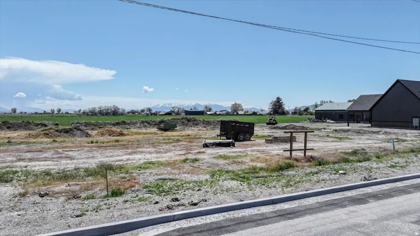 Cleared land parcel with a paved road frontage and curb