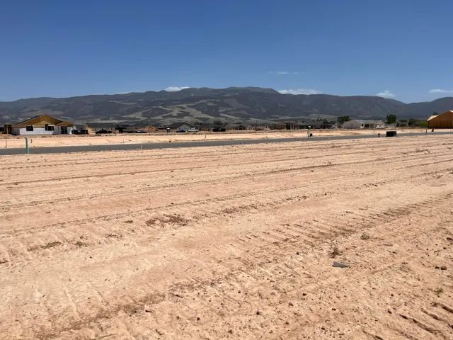 Expansive vacant lot featuring a cleared, level surface and distant mountain backdrop